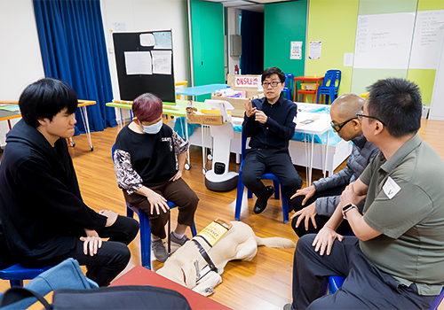 Journey Bright participants sitting in a circle with facilitators and a guide dog during a discussion.